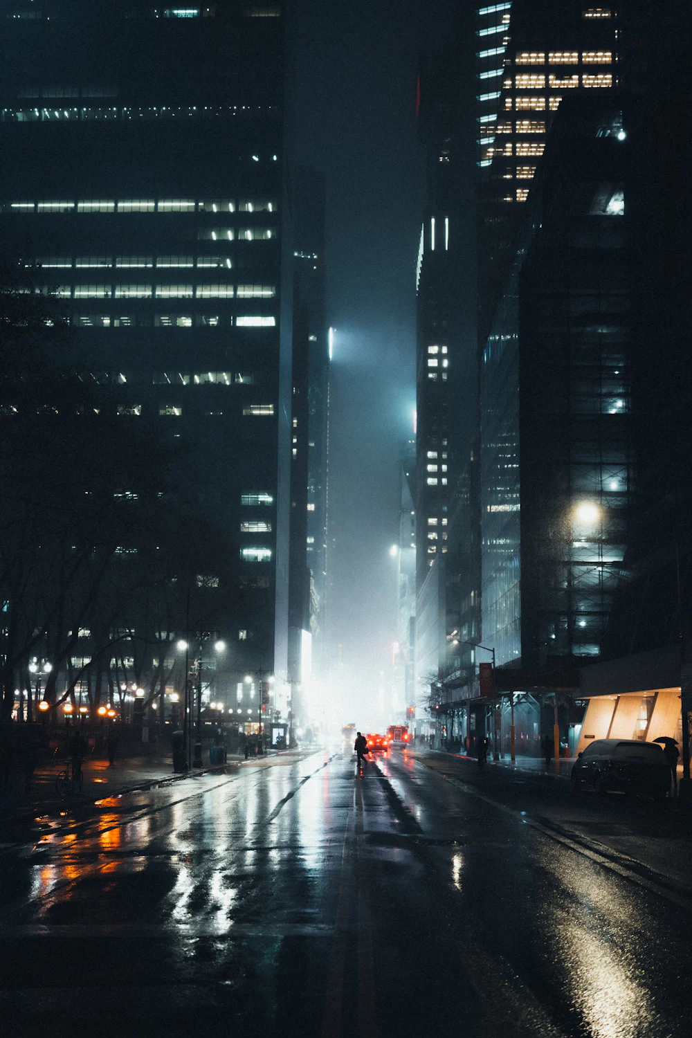 Calle urbana de noche con lluvia, reflejos y punto de fuga